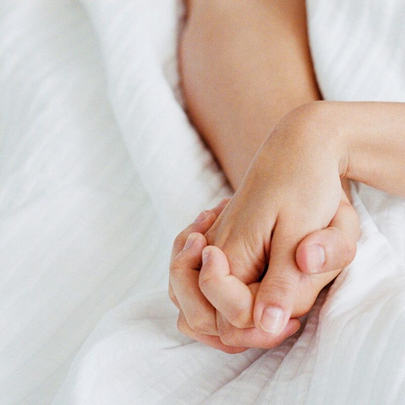 Holding hands in bed